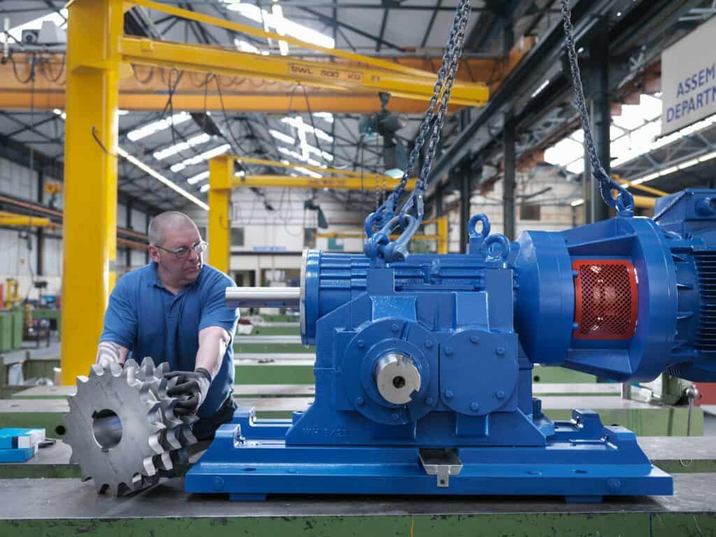 Engineer assembling industrial gearbox in engineering factory